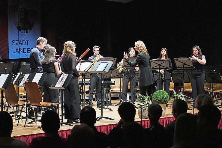 Mehrere Musikerinnen und Musiker spielen auf einer Bühne.