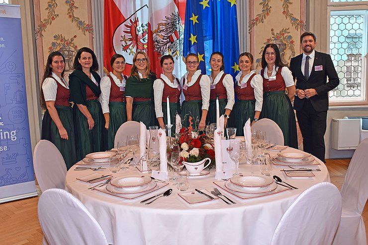 Gruppenfoto, im Vordergrund gedeckter Tisch