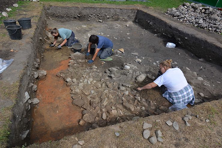 Auf dem Bild sind Archäologen der Universität Innsbruck zu sehen, die Proben bei der Ausgrabungsstätte entnehmen. 