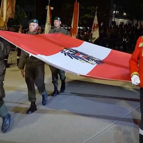 Österreichische Flagge, wird getragen von zwei Schützen und zwei Bundesheer Mitarbeitern