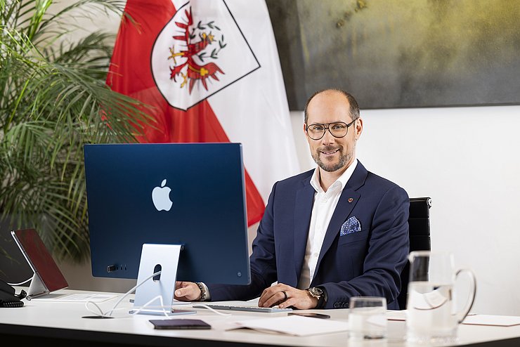 LR Mario Gerber in seinem Büro vor einem Computerbildschirm.