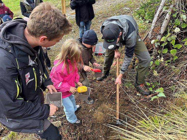 Erwachsener und Kinder graben Loch als Basis für Tisch