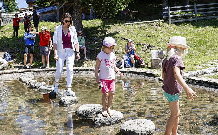 LRin Mair beim Wasserspaß mit Kindern im Alpbachtaler Lauserland.