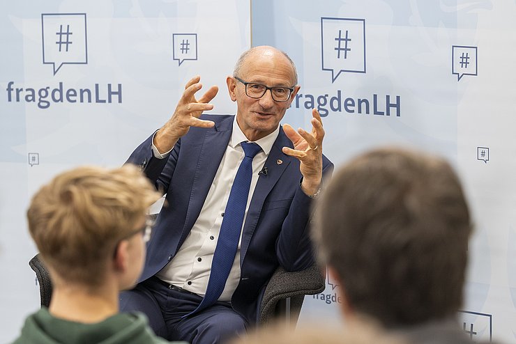 LH Mattle sitzt vor der Schulklasse und beantwortet die Fragen der SchülerInnen.