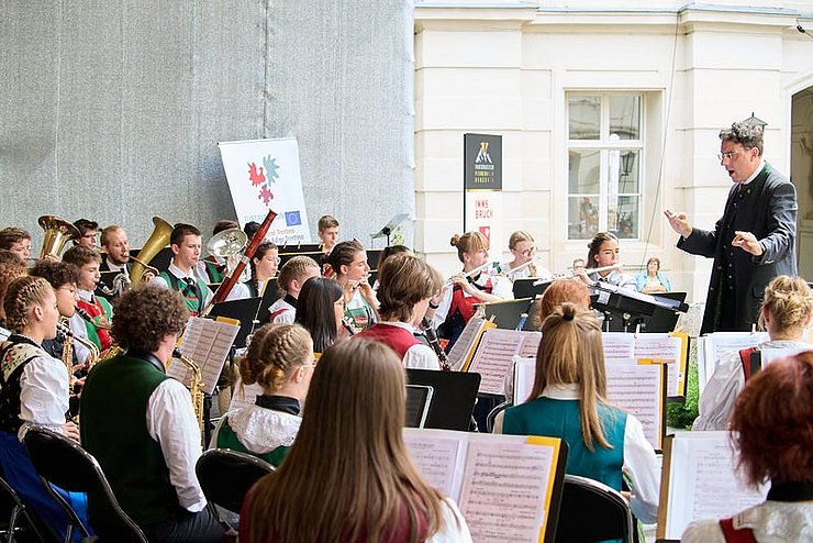 Das Euregio Jugendblasorchester spielt ein Stück und lässt sich von einem Dirigenten leiten.