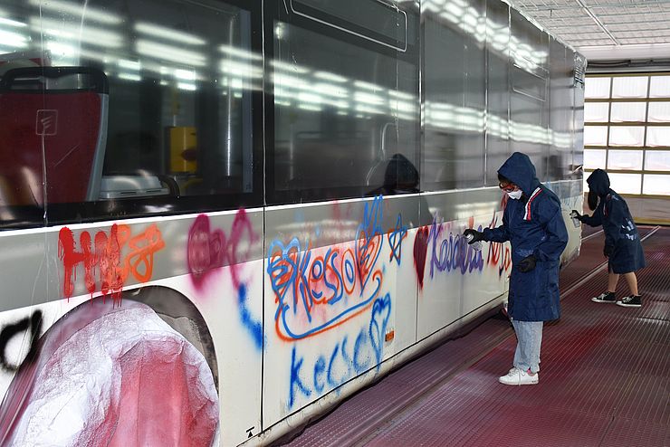 Bus mit bunten Aufschriften, 2 Mädchen beim Besprühen