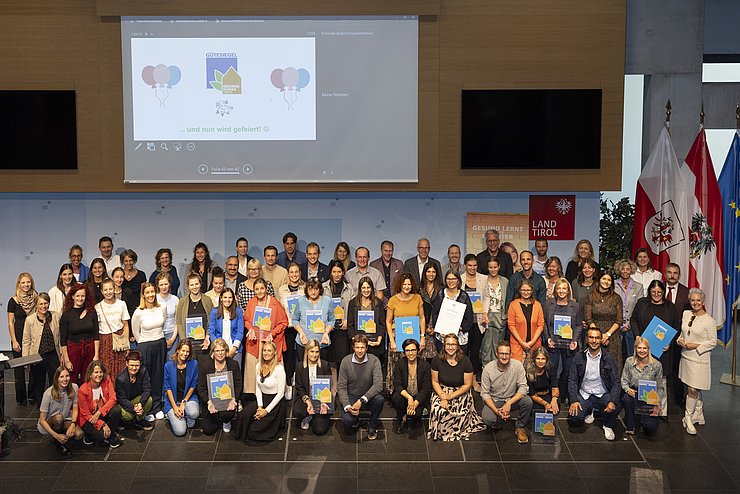 Alle Anwesenden der Veranstaltung stellten sich für ein Gruppenfoto auf die Bühne. Das Foto wurde von oben geschossen.