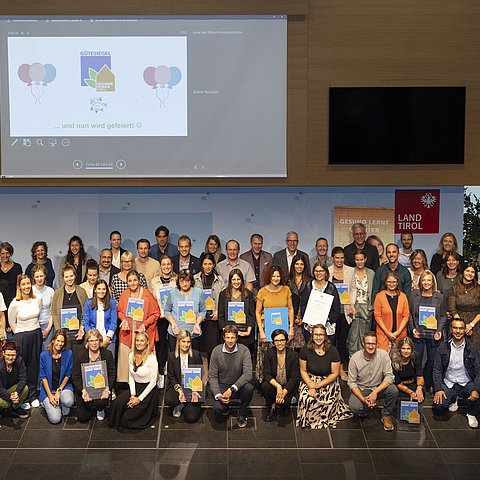 Alle Anwesenden der Veranstaltung stellten sich für ein Gruppenfoto auf die Bühne. Das Foto wurde von oben geschossen.