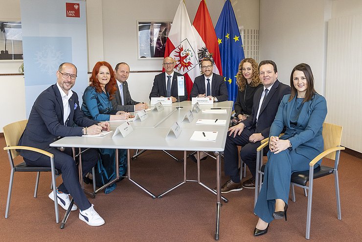 Die Tiroler Landesregierung an einem Tisch.