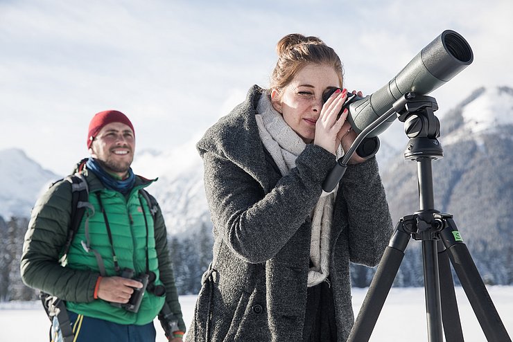 Frau schaut durch Fernglas