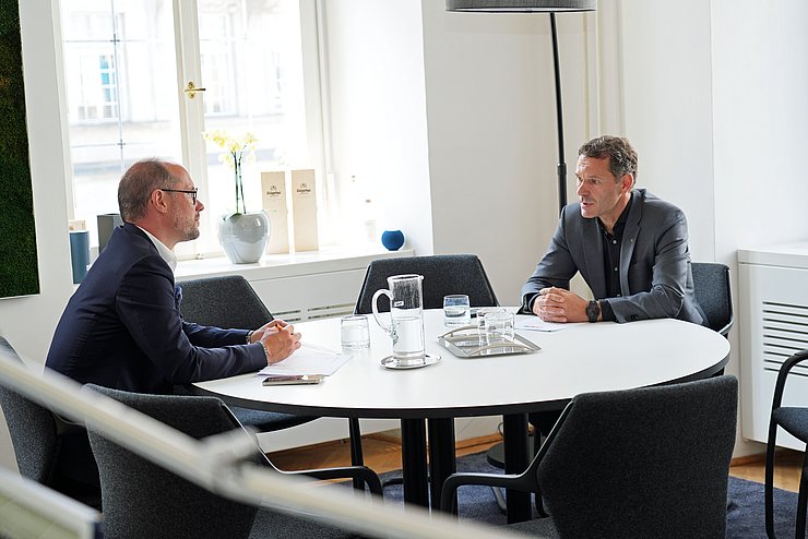 Zwei Menschen unterhalten sich am Tisch sitzend