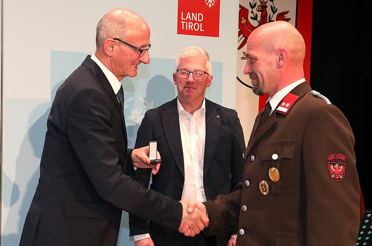 LH Mattle überreicht Rene Adelsberger die Tiroler Ehrenamtsnadel in Gold.