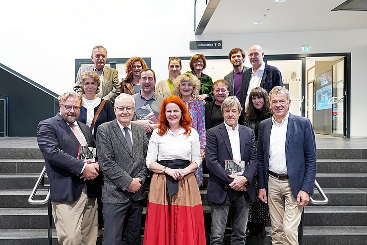 Mehrere Personen stehen auf einer Stiege im Landhaus.