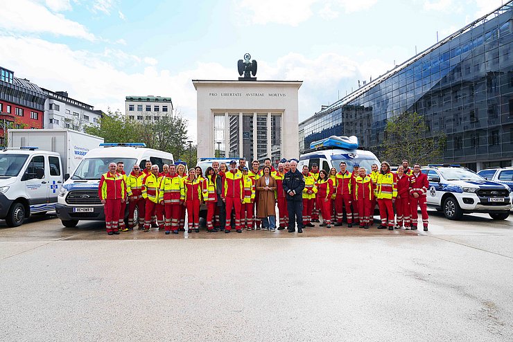 Gruppenfoto am Landhausplatz; im Hintergrund Fahrzeuge der Wasserrettung