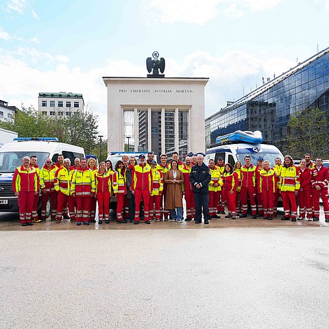 Gruppenfoto am Landhausplatz; im Hintergrund Fahrzeuge der Wasserrettung