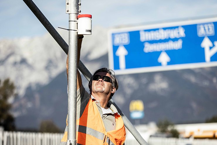 Mann mit Warnweste neben Autobahn 