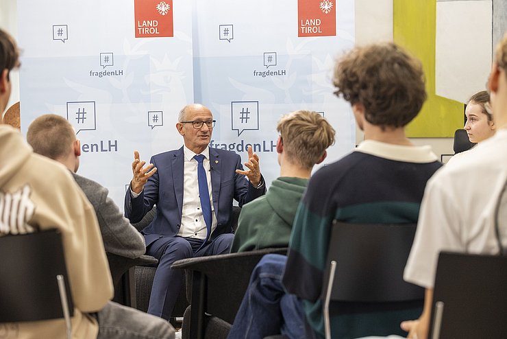 LH Mattle sitzt vor der Schulklasse und beantwortet die Fragen der SchülerInnen.