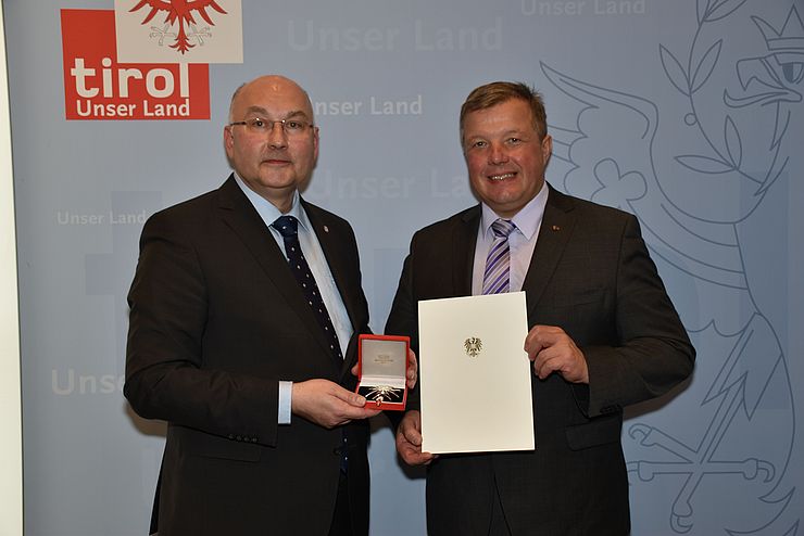 Gesundheitslandesrat Tilg gratuliert Landessanitätsdirektor Katzgraber (li.) zum Großen Ehrenzeichen für Verdienste um die Republik Österreich.