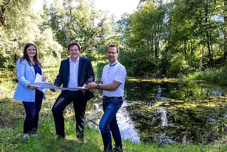 Auf dem Bild sind Stefanie Holzer von Revital, LR René Zumtobel und Projektleiter Gernot Guggenberger vor dem Teich zu sehen