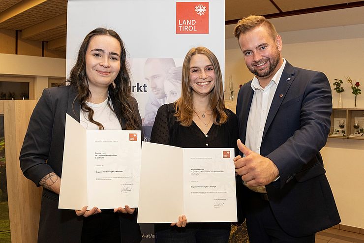 V. li. bei der Auszeichnungsfeier Daniela Lenz (Hotelkauffrau im dritten Lehrjahr bei der Hotel Mallaun GmbH), Magdalena Maass (Tapeziererin und Dekorateurin im ersten Lehrjahr bei Christine Schiechtl) und Landtagsabgeordneter Dominik Traxl.