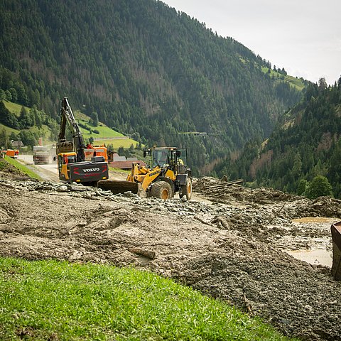 Bagger stehen auf Straße und räumen Mure weg