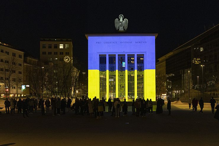 Denkmal am Landhausplatz leuchtet in blau-gelb, den Farben der ukrainischen Flagge.