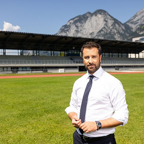 LHStv Georg Dornauer auf einem Fußballfeld mit einer Tribüne im Hintergrund.