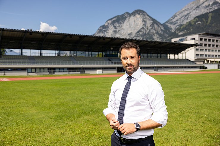 LHStv Georg Dornauer auf einem Fußballfeld mit einer Tribüne im Hintergrund.