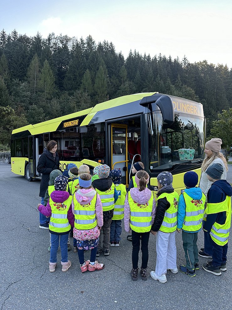 Kinder vor einem gelben Linienbus