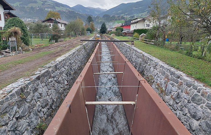 Ein Bach mit Schutzbauten an den Seiten.