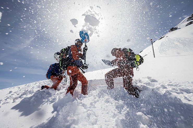 Männer im Schnee am Berg Loch grabend