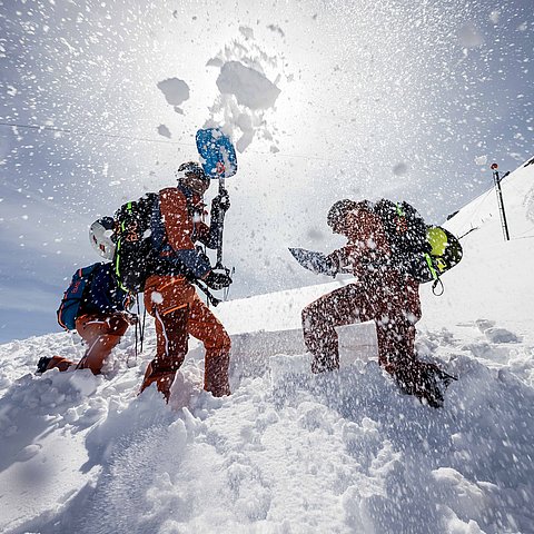 Männer im Schnee am Berg Loch grabend