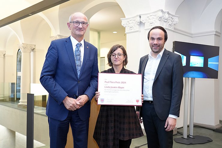 Landeshauptmann Anton Mattle und Landesrat Philipp Achammer (Südtirol)überreichten den Paul-Flora-Preis 2024 an Linda Jasmin Mayer.