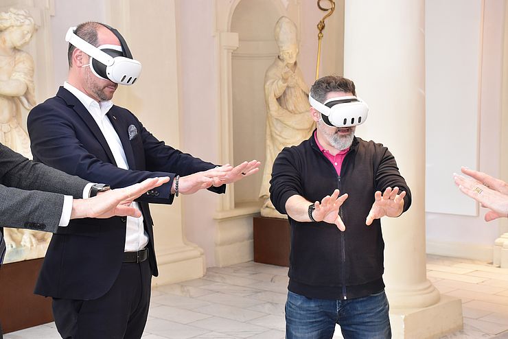 zwei Menschen mit VR-Brille greifen um sich