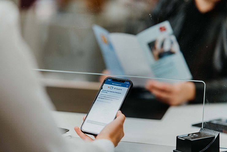 © Land Tirol/Charly Schwarz Person beim Bürgerservice hält Handy in der Hand